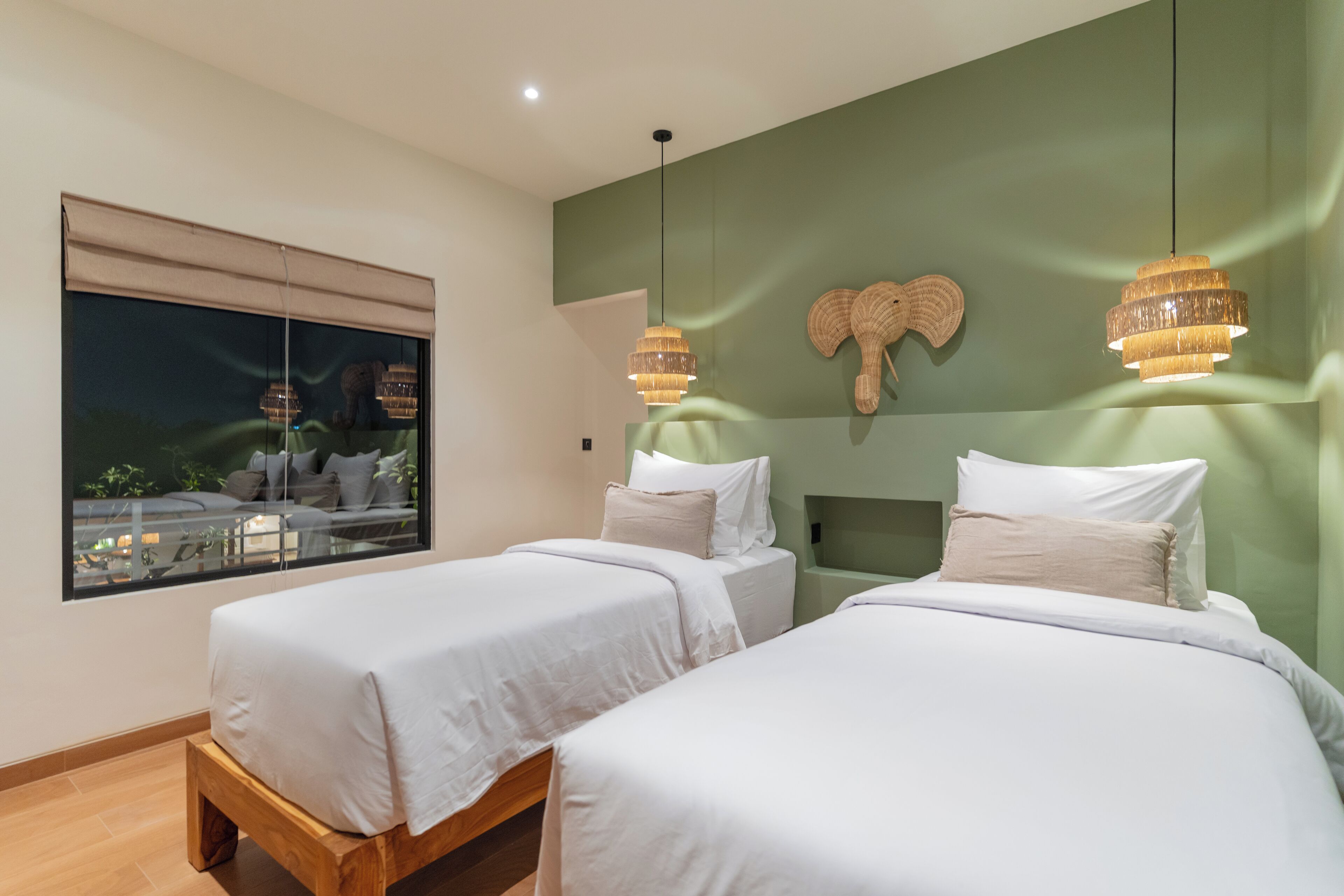 Ein Hotelzimmer mit zwei Betten, einem großen Fenster mit Blick und einer außergewöhnlichen Wanddekoration.