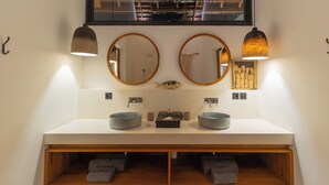 A modern bathroom with two sinks, two round mirrors, and a wooden vanity. - Villa Nador by Alfred in Bali (Seminyak)