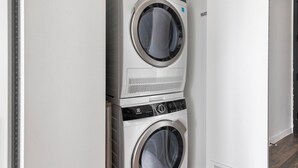 A stacked washer and dryer unit in a hallway. - Blueground | Near North Side, rooftop, nr Chicago River (Chicago)