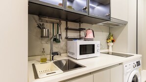 Eine moderne Küche mit integriertem Mikrowellenherd, Spüle und Waschmaschine.