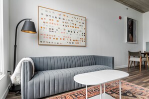 A modern living room with a grey sofa, a white coffee table, a black floor lamp, and a patterned rug. - Blueground | Near North Side, rooftop, nr Riverwalk (Chicago)