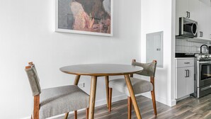 Eine moderne Küche mit weißen Schränken, einer eingebauten Mikrowelle und einem Edelstahlbackofen.