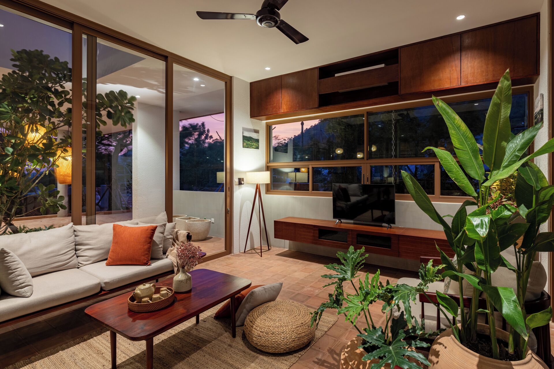 Una sala de estar moderna con sofá, mesa de centro y grandes ventanales con vistas panorámicas.