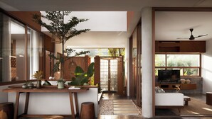 A modern living room with a large TV, a sofa, and a dining area with a wooden table and chairs. - Amaya Kampot (Kampot)