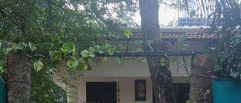 Un bĂątiment avec une entrĂ©e rouge, un porche abritĂ© et un chemin de terre menant Ă lâentrĂ©e.