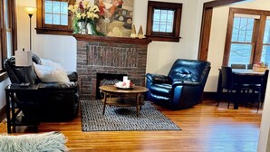 A cozy living room with a fireplace, leather sofas, a coffee table, and a bookshelf with books. - Urban Hideaway
Como, U of M, Stadiums, downtown Mpls & St Paul, MOA, MSP AirPort (Minneapolis)