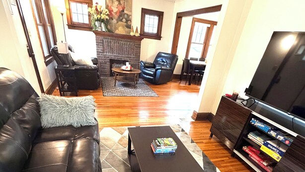 A living room with a black leather sofa, a coffee table, and a TV stand with books. - Urban Hideaway
Como, U of M, Stadiums, downtown Mpls & St Paul, MOA, MSP AirPort (Minneapolis)