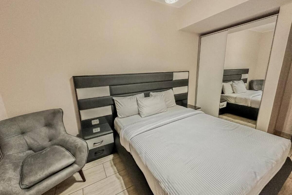 Une chambre à coucher comprenant un lit, une table de chevet, une chaise et une armoire.
