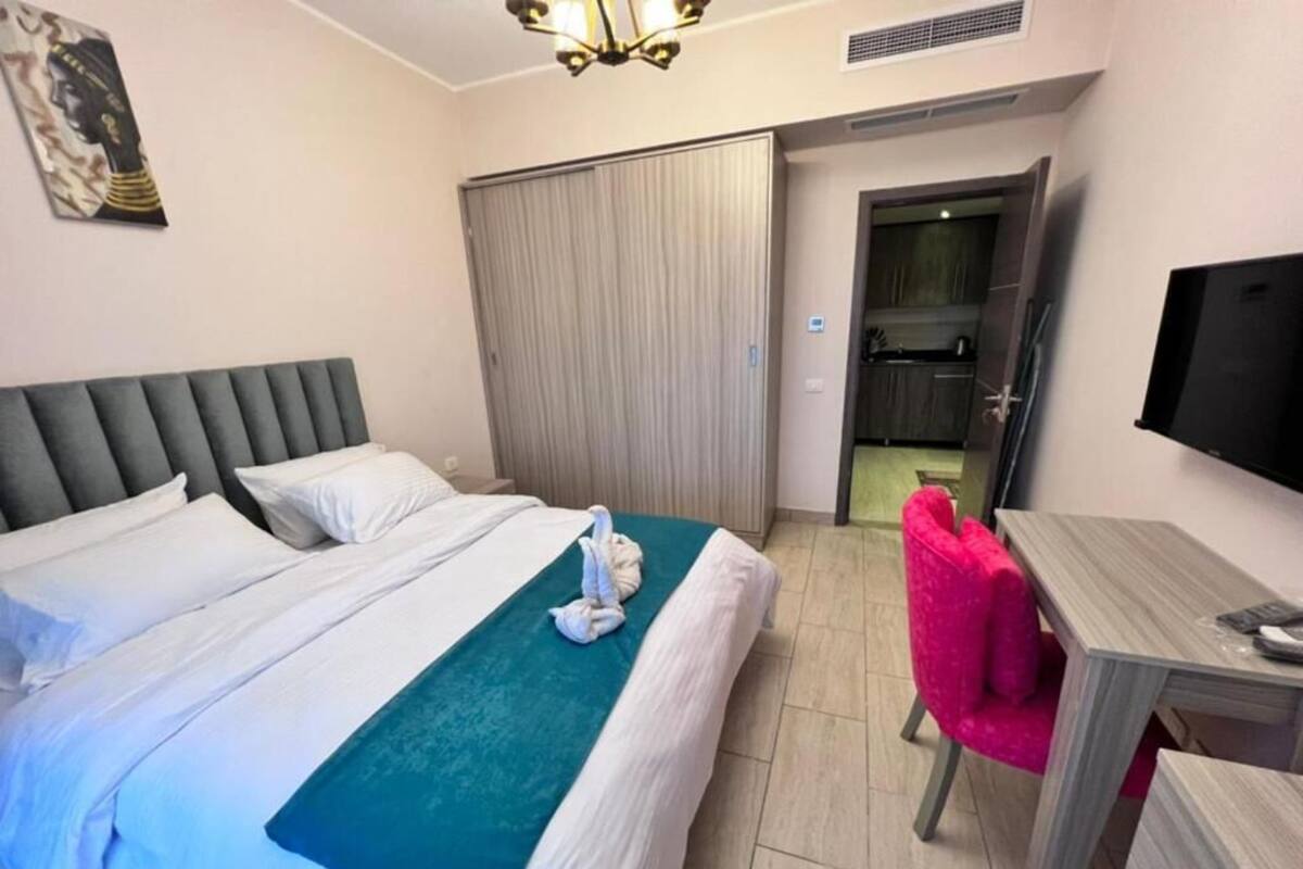 Une chambre d’hôtel équipée d’un lit, d’un bureau, d’une chaise, d’une télévision et d’une armoire.