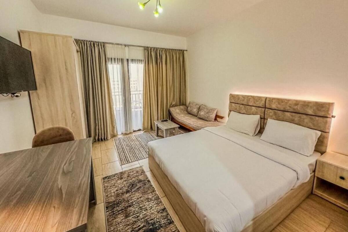 Une chambre d’hôtel avec un grand lit, un bureau, une télévision et un canapé.