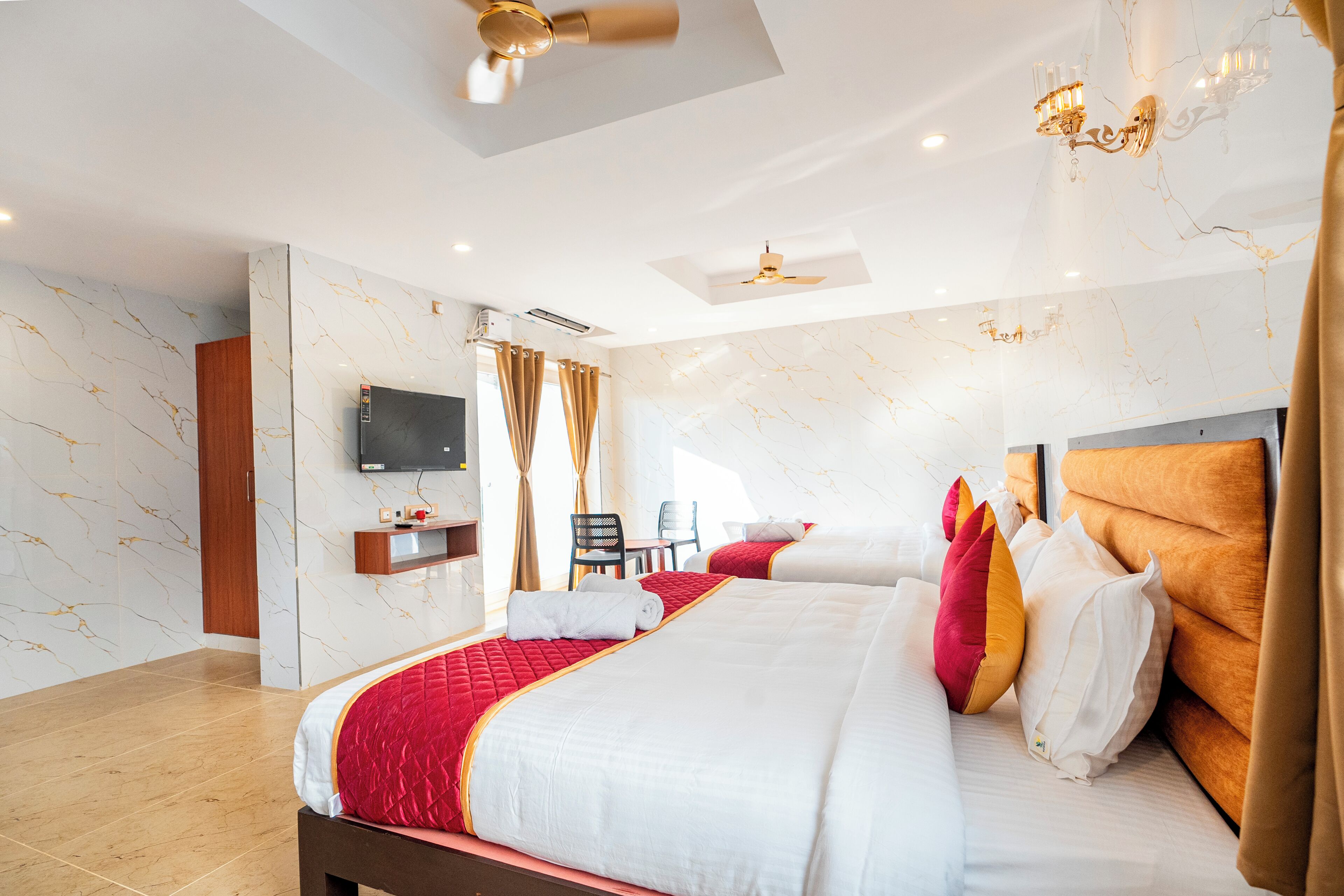 Una habitación de hotel con una cama grande, televisión, escritorio y una silla.