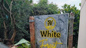Placa de White Forest, uma unidade da PV Hotels, com paisagem natural ao fundo.