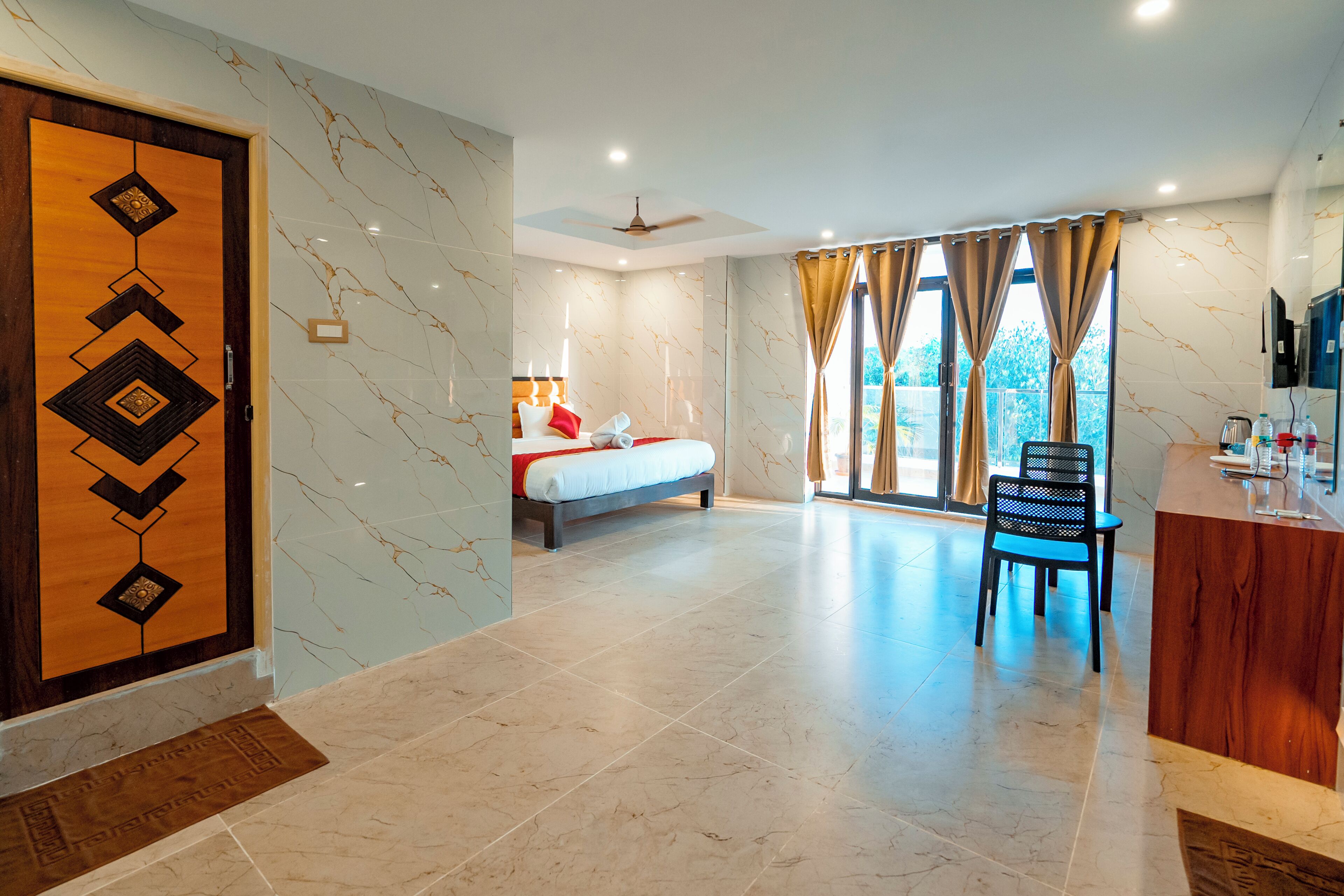 Habitación de hotel con cama, escritorio, silla y vistas al exterior.