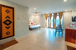 Ein Hotelzimmer mit Bett, Schreibtisch, Stuhl und Blick ins Freie.