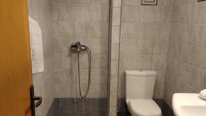 Ein Badezimmer mit Dusche, Toilette und Waschbecken.