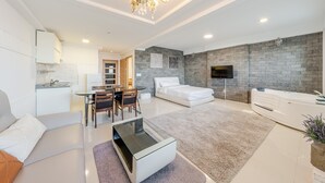 Ein modernes, helles Wohnzimmer mit Sofa, Couchtisch und Essbereich.