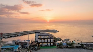 Un edificio sul lungomare con vista sul mare al tramonto.