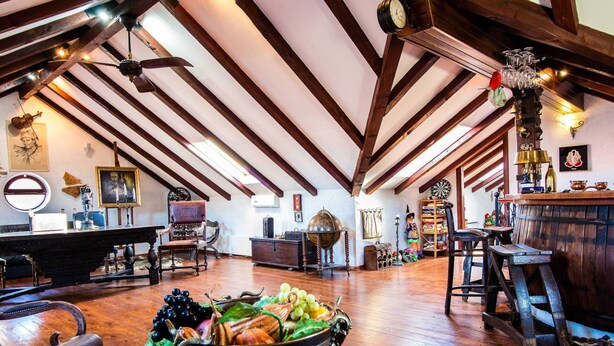 Ein geräumiger Loft mit freiliegenden Holzbalken, einer Holztresorecke und verschiedenen antiken sowie dekorativen Gegenständen.