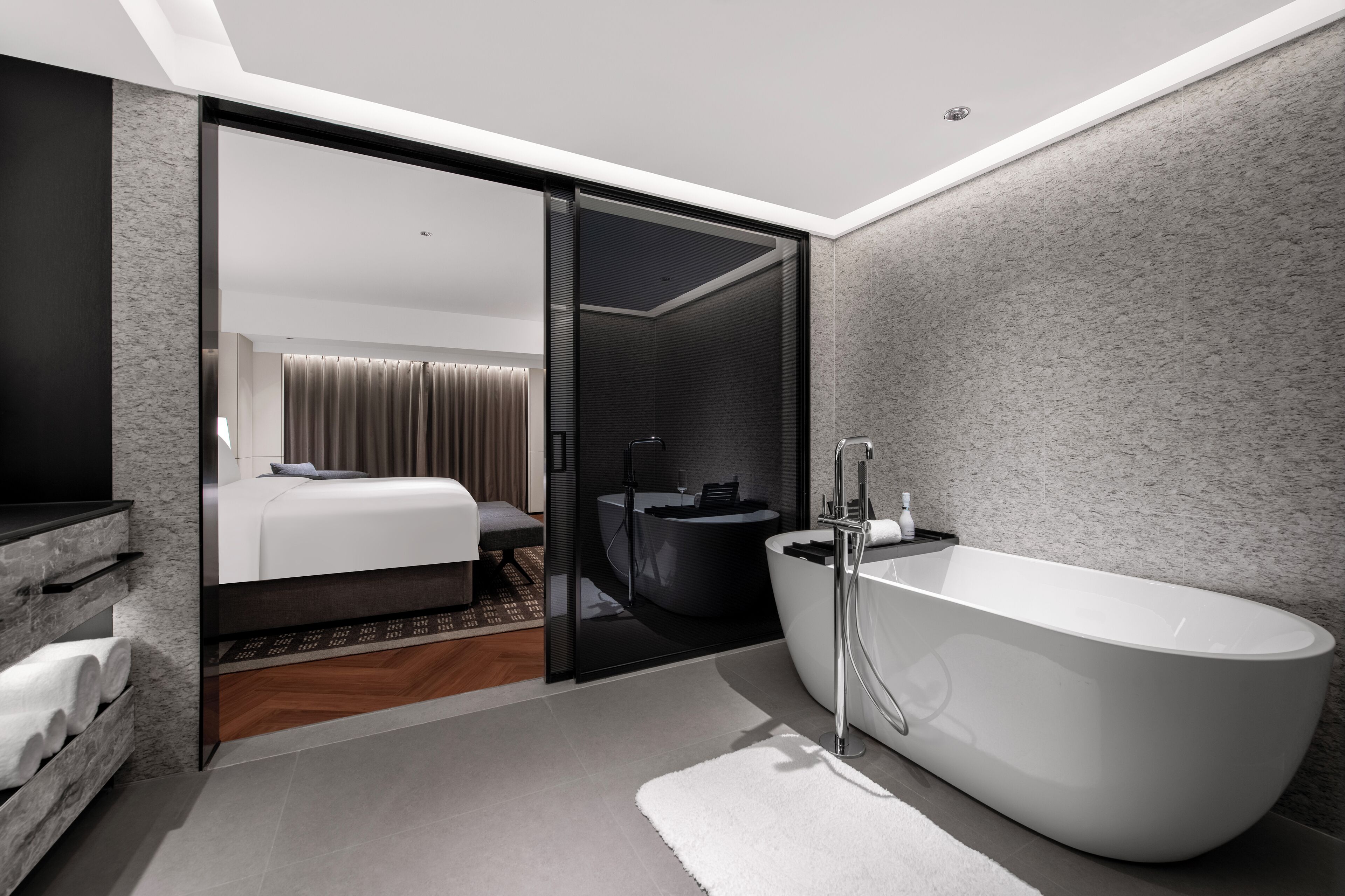 A modern bathroom with a freestanding bathtub, a large mirror, and a glass shower enclosure.