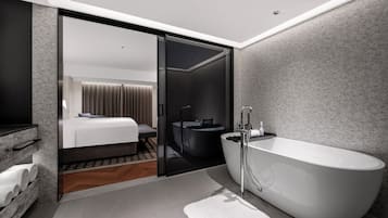 Un baño moderno con una bañera independiente, un espejo grande y una cabina de ducha de vidrio.