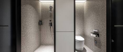 A modern bathroom with a shower, toilet, and towel rack.