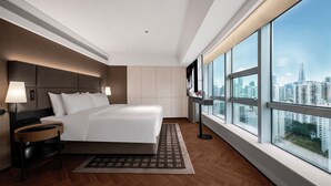 A modern hotel room with a large bed, a nightstand, a TV, and a city view through large windows. - IntercityHotel Shenzhen Huaqiang North (Shenzhen)