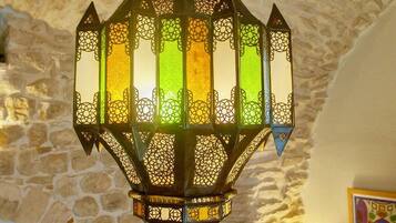 A decorative lantern with intricate patterns and a stone wall background.