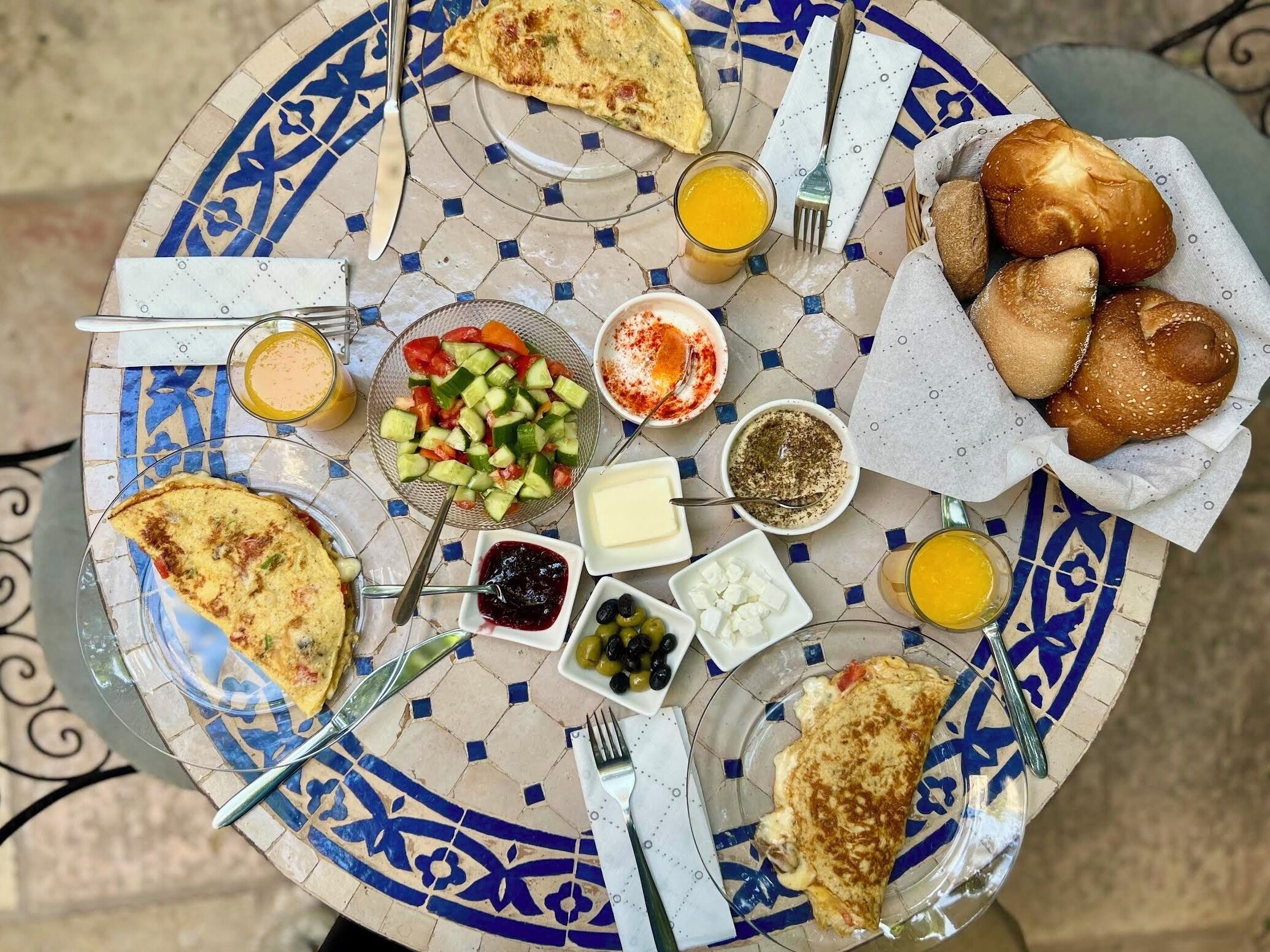 A table with a variety of breakfast items including toast, eggs, a salad, and beverages.