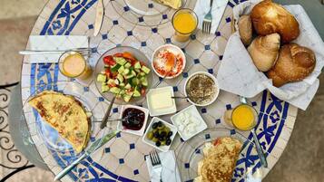 A table with a variety of breakfast items including toast, eggs, a salad, and beverages.