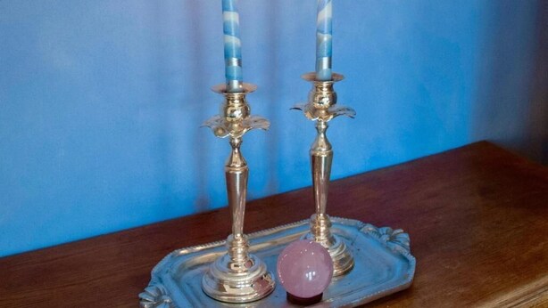 Two lit candles on a silver tray with a decorative item. - Artist Quarter Guesthouse B&B (Safed)