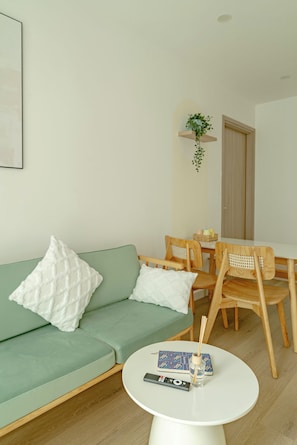 Deluxe Apartment, Balcony, Pool View | Living area | 55-inch LED TV with cable channels, streaming services - Ti Tach Home in Nera Garden Hue (Thua Thien Hue)