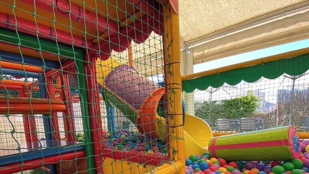 Een speelruimte met een bällebak en glijbanen.