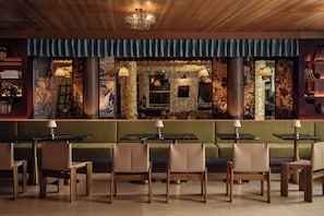 Ein Restaurant mit einer grünen Sitzgruppe, Holztischen und -stühlen.