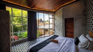 A bedroom with a large window, a bed, and a view of the outdoors. - dedeane ubud (Ubud)