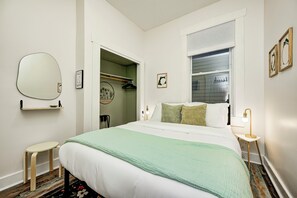 A neatly arranged bedroom with a bed, bedside table, lamp, and a closet with hanging clothes. - HotTub~FirePit~Games~YogaNook~5 Mins to Downtown (Indianapolis)