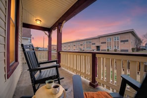 A porch with a table, two chairs, and a cup of coffee. - HotTub~FirePit~Games~YogaNook~5 Mins to Downtown (Indianapolis)