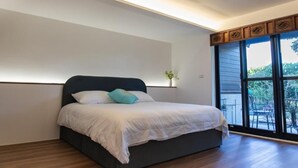 A modern bedroom with a large bed, a small bedside table, and a window with a view of the outdoors. - Slow Travel Space for Neighbors (Wujie)