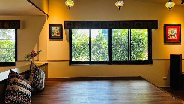 A room with a large window, wooden flooring, and hanging pendant lights. - Slow Travel Space for Neighbors (Wujie)