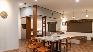 A modern living room with a dining area, wooden flooring, and a large window with a view. - Slow Travel Space for Neighbors (Wujie)