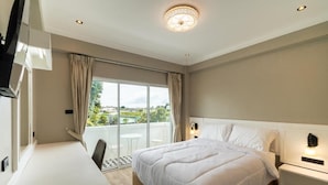 Une chambre d’hôtel avec un grand lit, un bureau et un balcon offrant une vue agréable.