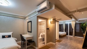 Une chambre d’hôtel avec un lit, un bureau et une petite salle de bain.