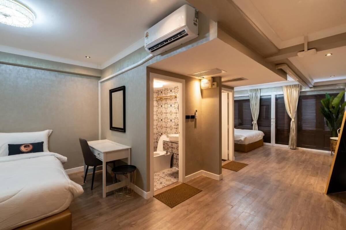 A hotel room with a bed, desk, and a small bathroom.