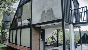 Ein modernes Haus mit einer großen, offenen Terrasse, einem Balkon und Blick auf die umliegende Landschaft.