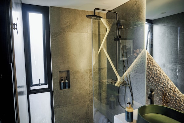 A modern bathroom with a glass-enclosed shower, a bathtub, and a window. - Solitude Villa Tahura (Lembang)