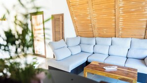 Una sala de estar moderna con un sofá seccional azul claro, una mesa de centro de madera y una estructura de techo de madera.