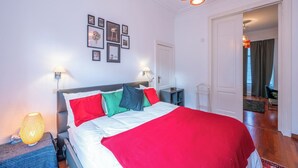 A neatly arranged bedroom with a bed, bedside lamps, and wall art. - Room-euro Edens Brussels - Cozy Family S (Brussels)