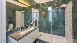 A modern bathroom with a glass-enclosed shower, a large mirror, and a vanity with a sink. - Room-euro Edens Brussels - Cozy Family S (Brussels)