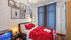 A hotel room with a bed, a TV, a bedside table, a mirror, and a wardrobe. - Room-euro Edens Cosy Historic Home in Br (Brussels)