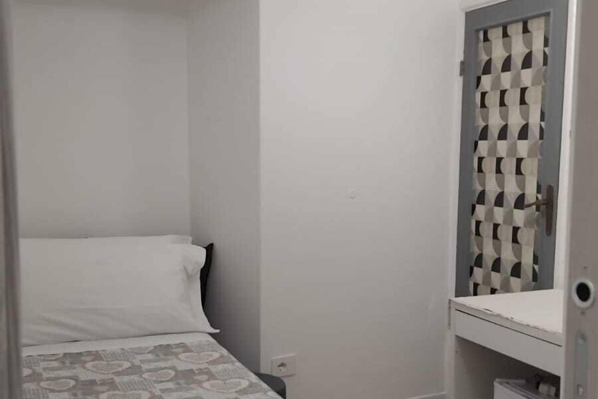 Un dormitorio pequeño y acogedor con cama, mesita de noche y armario.