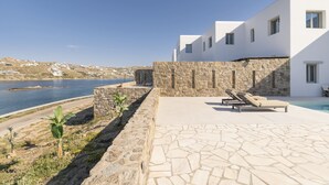 A modern building with a stone wall and a pool area. - Denia Seaside Villa III,Private Heated Pool! (Mykonos)